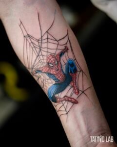 Colour Spider-Man tattoo on the forearm, swinging across a fine black spider web