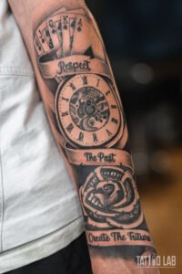 Black and grey forearm sleeve with poker cards, pocket watch, rose and "Respect The Past Create The Future"