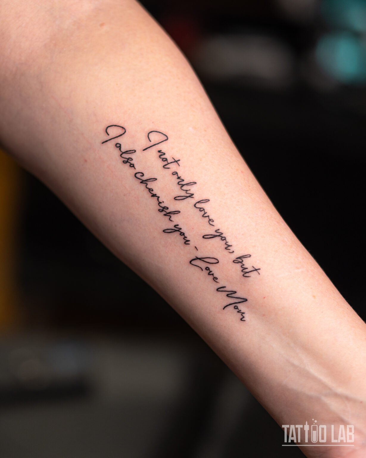 Handwritten script tattoo on the forearm reading "I not only love you, but I also cherish you – Love Mom", Tattoo Lab, Halifax