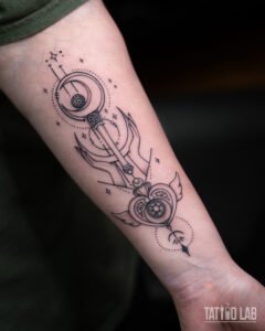 Fine line forearm tattoo of a crescent moon wand and winged heart with reaching hands, stars and dotted orbits