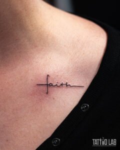 Fine line script tattoo reading "faith" with a cross worked into the lettering, just below the collarbone