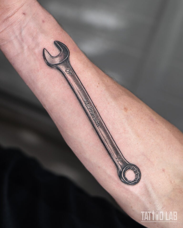Wrench tattoo on forearm, realistic black and grey tool design by Tattoo Lab Halifax Nova Scotia.
