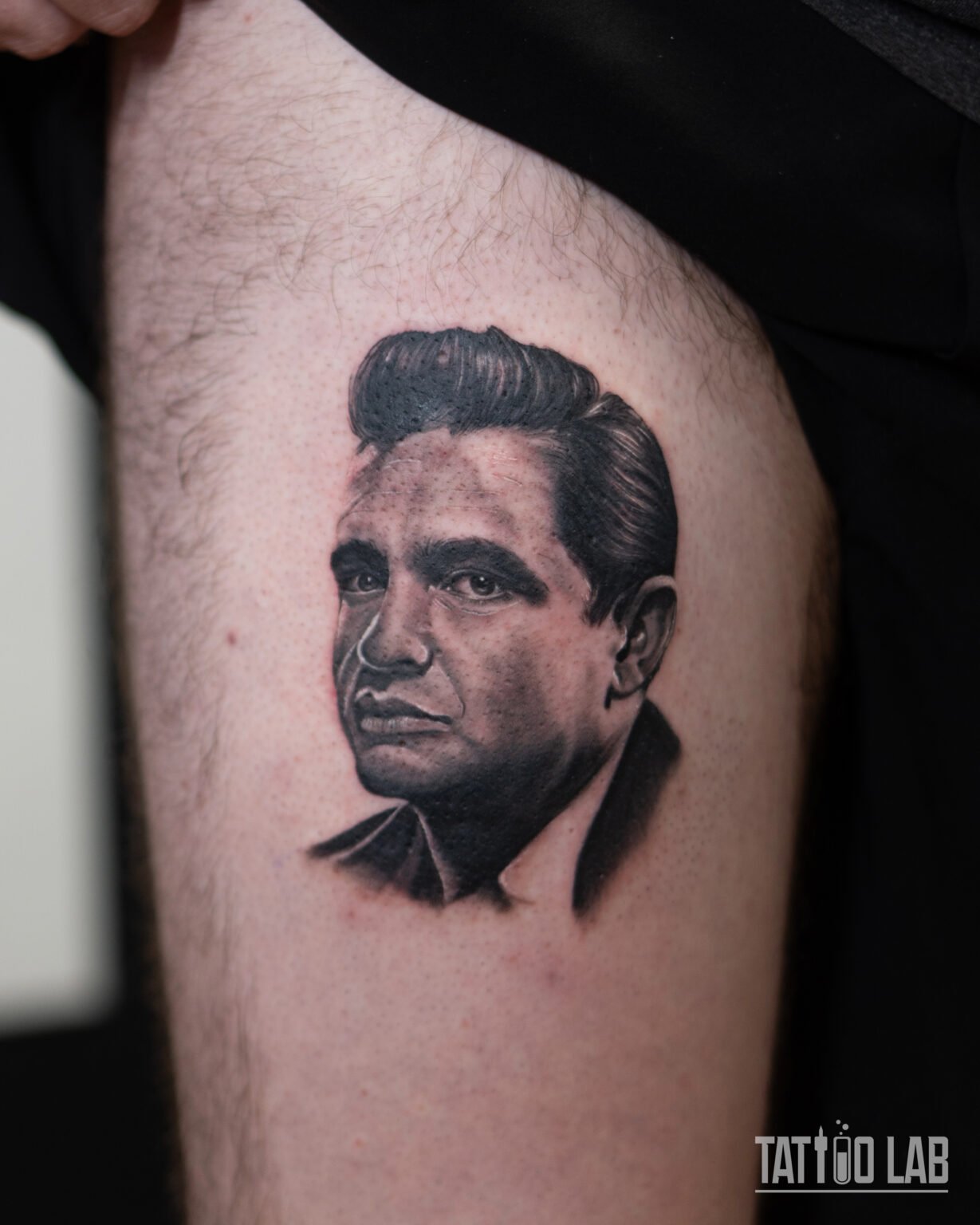 Black and grey realism portrait tattoo of Johnny Cash on the thigh with soft, detailed shading, Tattoo Lab, Halifax