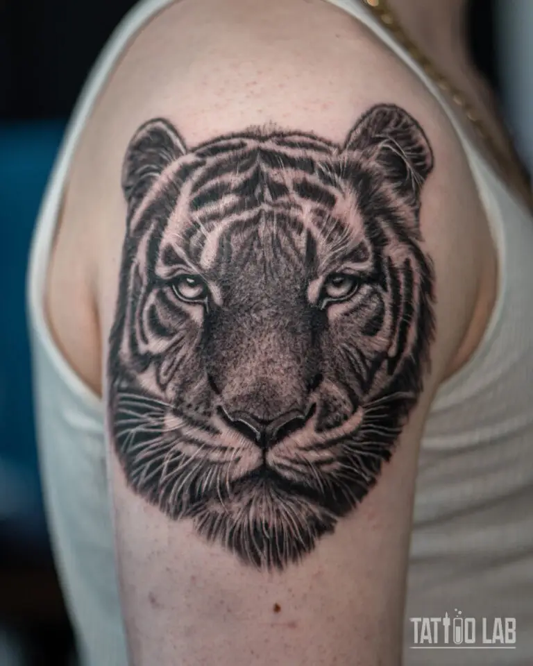 Black and grey realism tiger head tattoo on the shoulder with detailed fur and eye shading