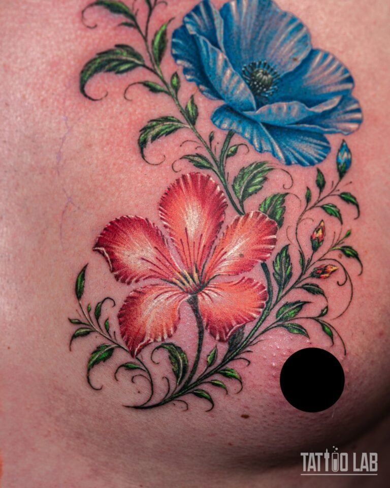 Full view of a colour realism blue poppy and red hibiscus chest tattoo with green vines and small buds